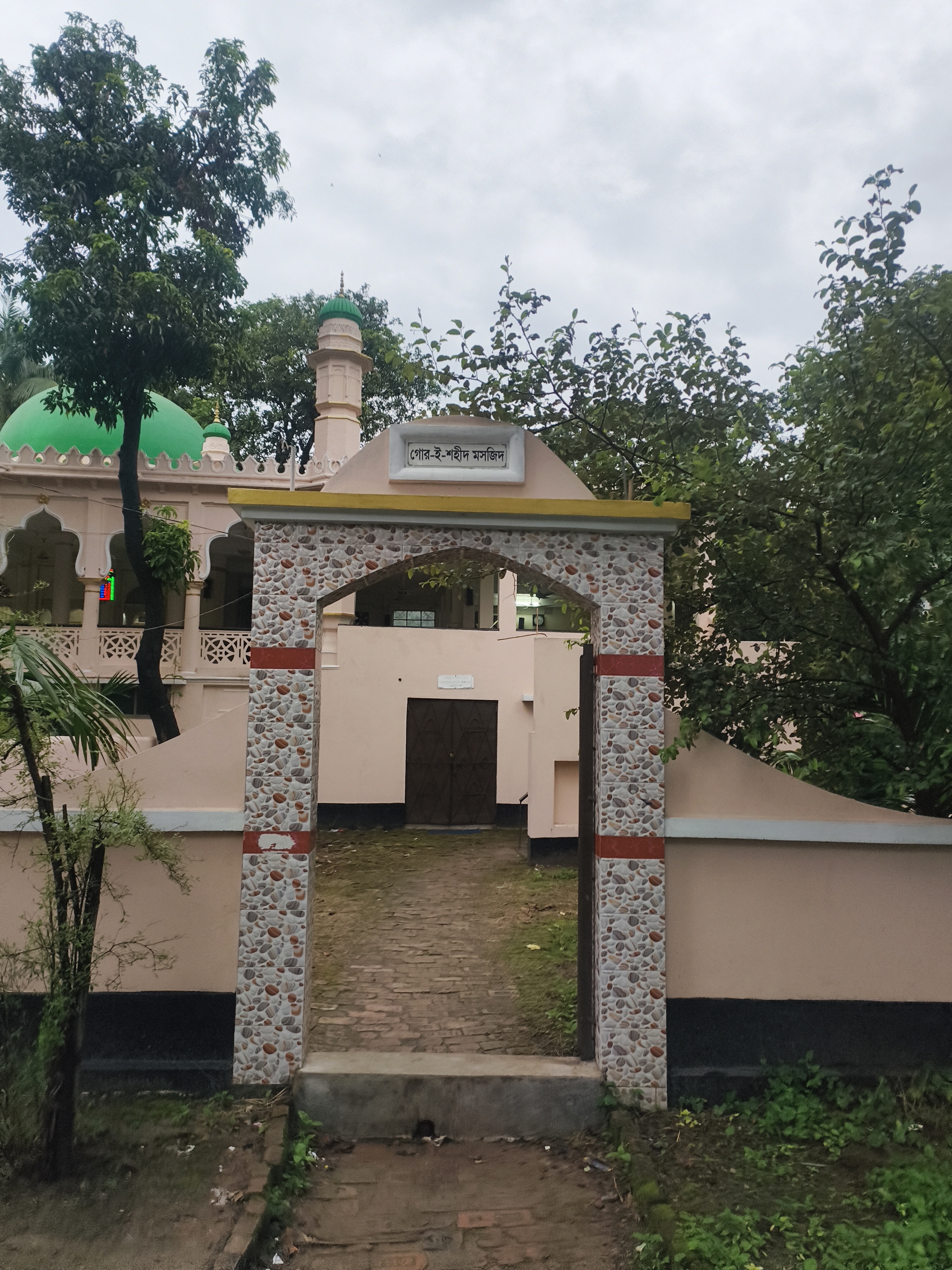 গাছপালার আড়াল থেকে উঁকি দিচ্ছে মসজিদের সবুজ গম্বুজ আর মিনার। ১৯৩৮ সালে মুতাওয়াল্লি নিজে উদ্যোগ নিয়ে এই মসজিদটি সম্প্রসারণ করেছিলেন।